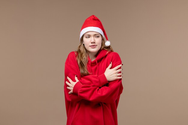 Ragazza di natale di vista frontale che trema sul natale di festa del modello del fondo marrone