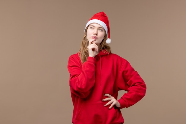 Ragazza di natale di vista frontale con il fronte di pensiero sullo sfondo marrone vacanze capodanno natale