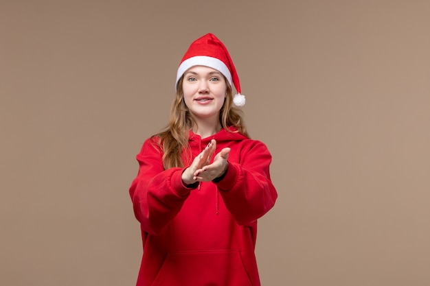 Ragazza di natale di vista frontale con il fronte emozionante su natale di feste della donna del fondo marrone