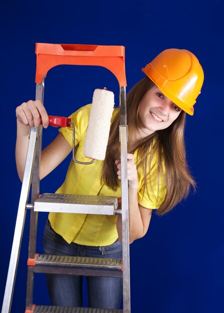 Ragazza di pittore con i rulli della vernice