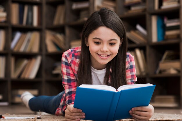 Ragazza di smiley che legge un romanzo