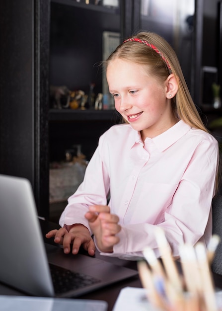 Ragazza di smiley che per mezzo della sua tastiera