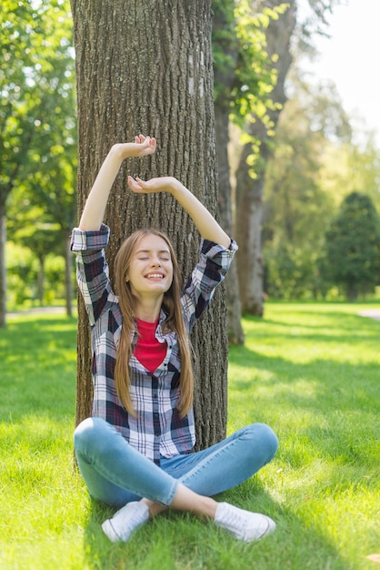 Ragazza di smiley che si siede sull'erba