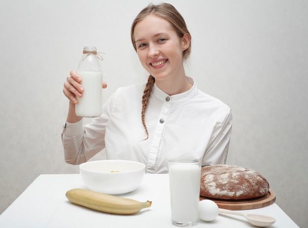 Ragazza di smiley che tiene una bottiglia di latte