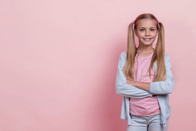 Ragazza di smiley con code di cavallo con le braccia incrociate