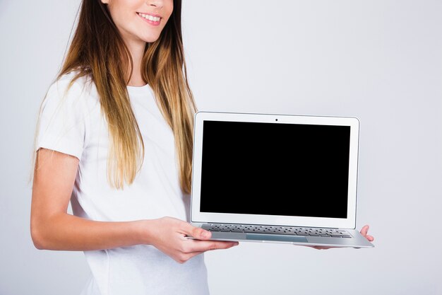 Ragazza di smiley con il suo computer portatile