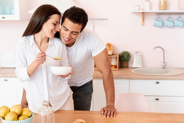 Ragazza di smiley del colpo medio che mangia prima colazione