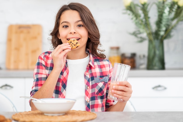 Ragazza di smiley di vista frontale che mangia prima colazione