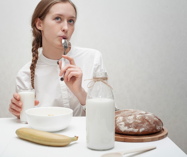 Ragazza di smiley di vista frontale che mangia una prima colazione deliziosa