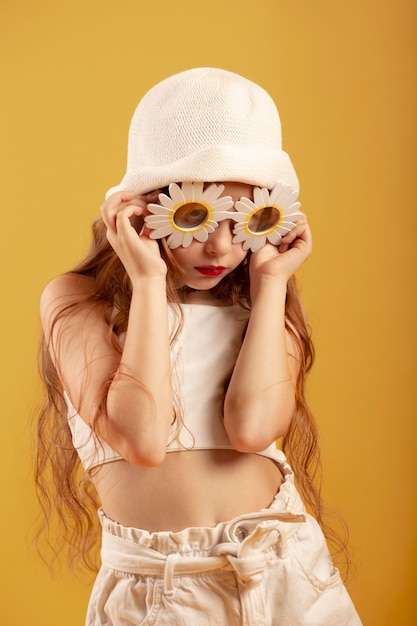 Ragazza di taglio medio che posa con il cappello