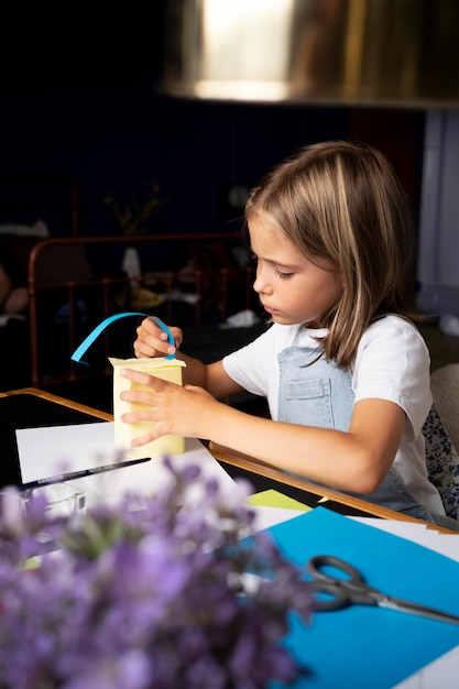 Ragazza di tiro medio che è creativa con la carta