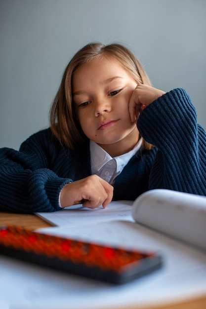 Ragazza di tiro medio che impara la matematica a scuola