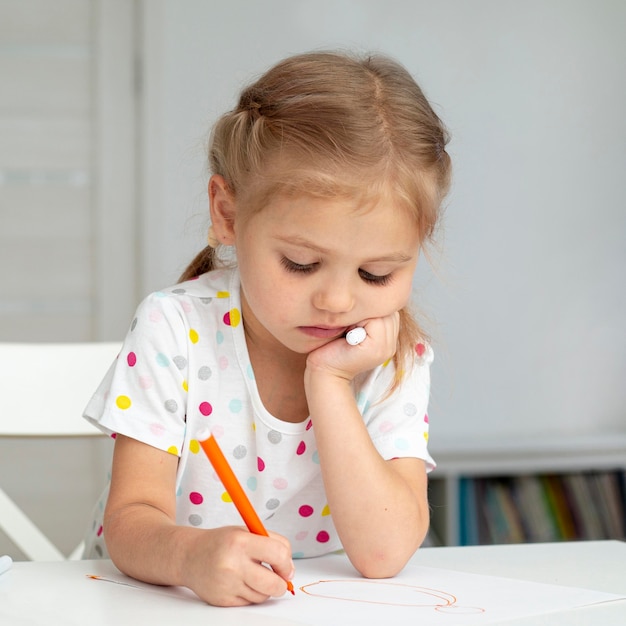 Ragazza di vista frontale a casa che disegna