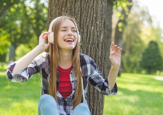 Ragazza di vista frontale che ascolta la musica all'aperto