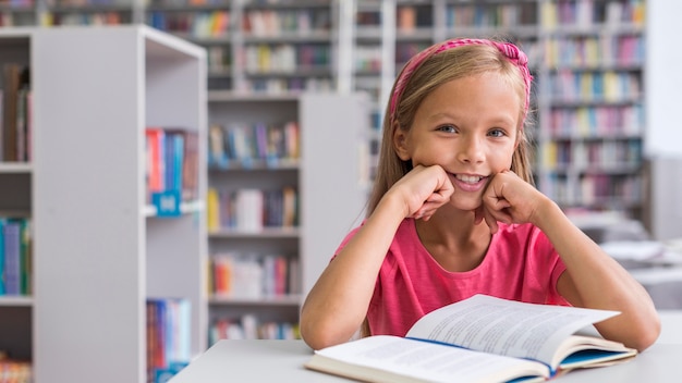 Ragazza di vista frontale che fa il suo lavoro in biblioteca