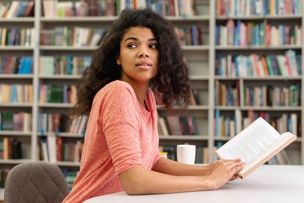 Ragazza di vista laterale allo studio delle biblioteche