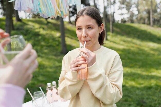 Ragazza di vista laterale che beve deliziosa limonata