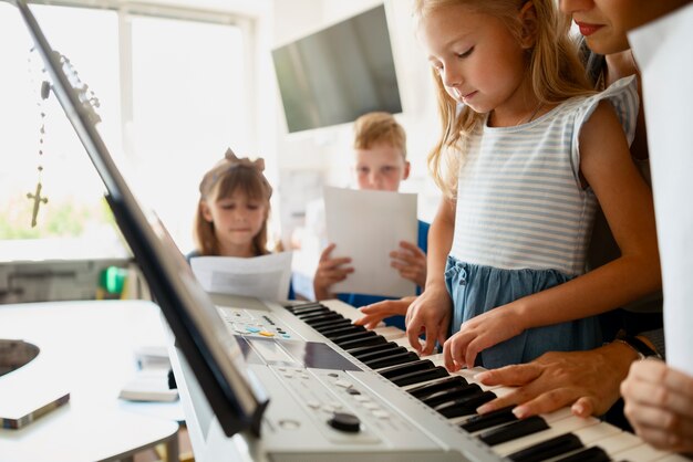 Ragazza di vista laterale che impara a suonare il pianoforte