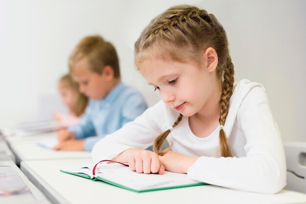 Ragazza di vista laterale che legge la sua lezione