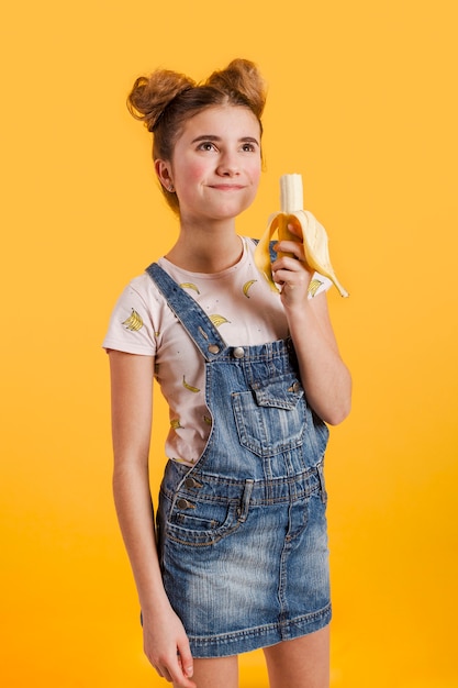 Ragazza di vista laterale che mangia banana