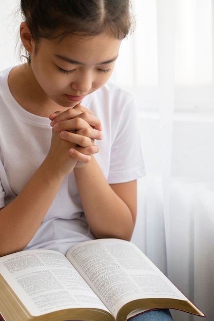 Ragazza di vista laterale che prega alla scuola domenicale