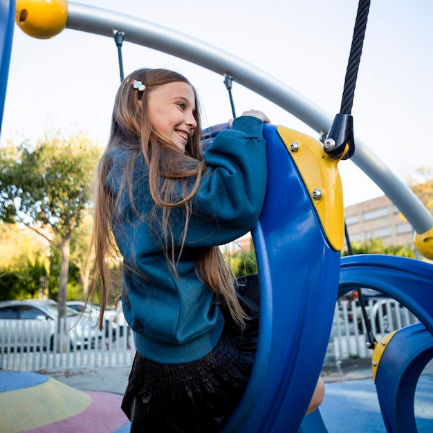 Ragazza di vista laterale che si diverte al parco giochi