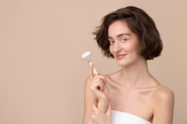 Ragazza di vista laterale che tiene il rullo di giada