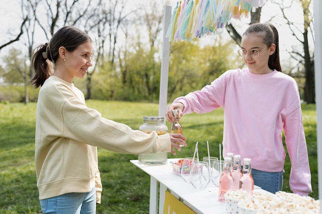 Ragazza di vista laterale che vende limonata fresca