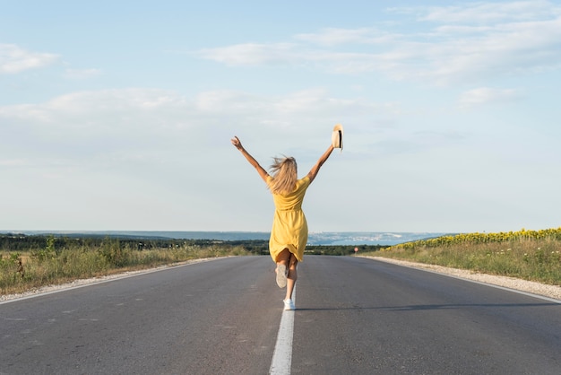 Ragazza di vista posteriore che corre in mezzo alla strada