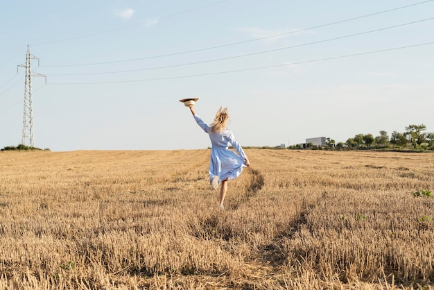 Ragazza di vista posteriore che corre in un campo