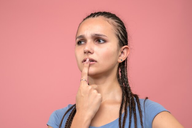 Ragazza di vista ravvicinata anteriore che pensa sul rosa