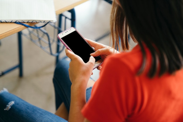 Ragazza distratta con il telefono in classe