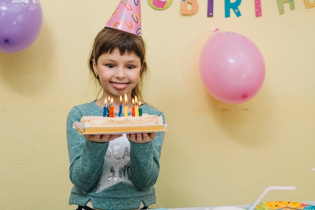 Ragazza divertente con torta di compleanno