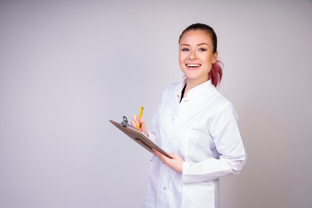 Ragazza divertente in uniforme bianca del medico