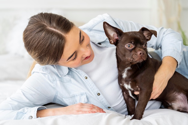 Ragazza e cane del colpo medio a letto