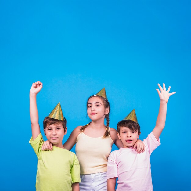 Ragazza e due ragazzi con braccio alzato su sfondo blu