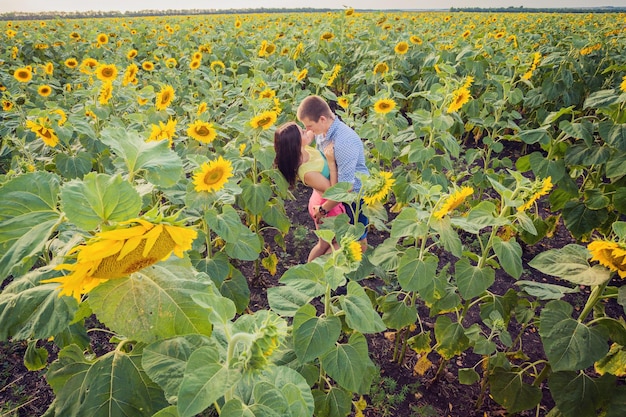 Ragazza e uomo in un campo di girasoli