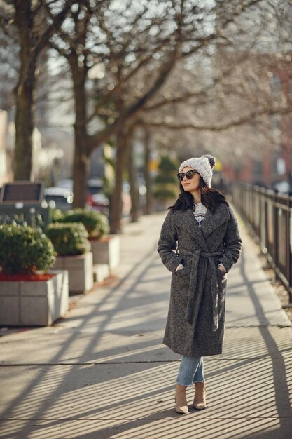 Ragazza elegante a piedi in una città invernale.