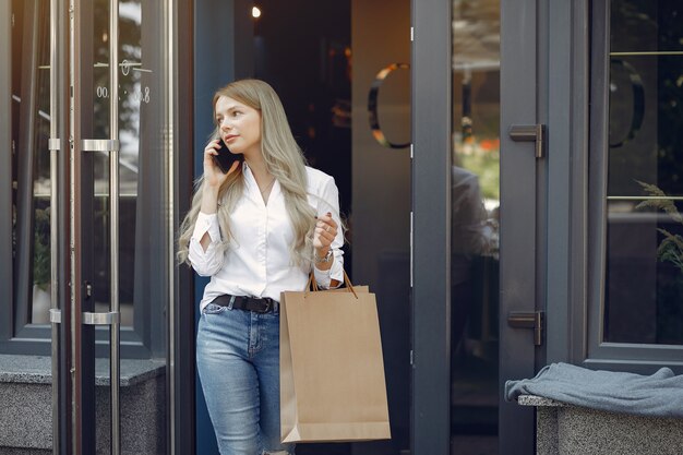 Ragazza elegante con il sacchetto della spesa in una città