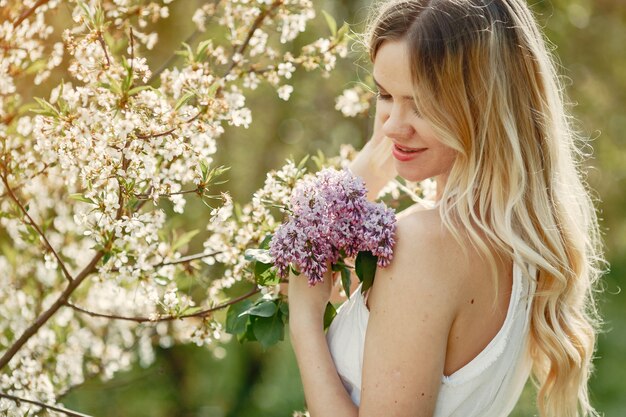 Ragazza elegante e alla moda in un parco di primavera