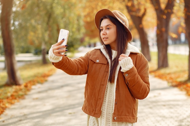 Ragazza elegante e alla moda in un parco in autunno