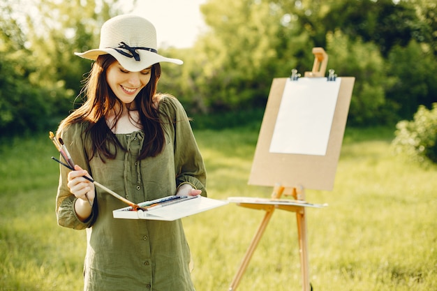 Ragazza elegante e bella pittura in un campo