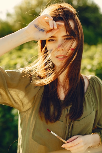 Ragazza elegante e bella pittura in un campo