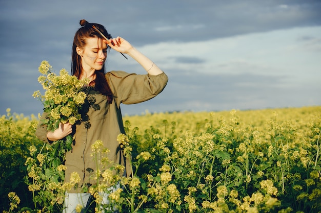 Ragazza elegante e bella pittura in un campo