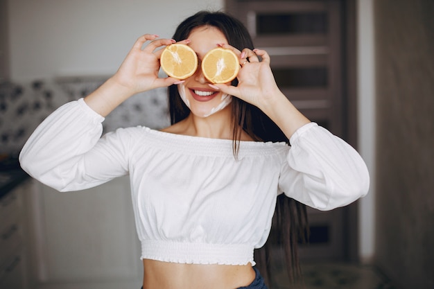 Ragazza elegante in una cucina con frutta