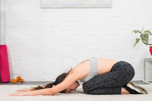 Ragazza facendo stretching in casa sua