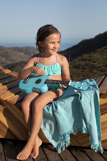 Ragazza felice a tutto campo con la chitarra