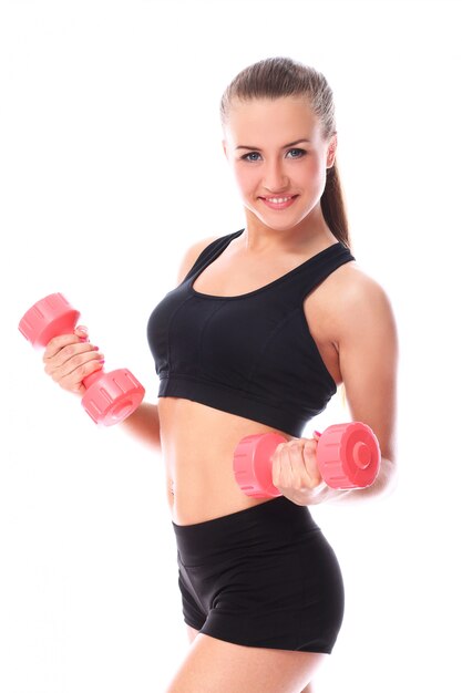 Ragazza felice che fa le esercitazioni con i dumbbells