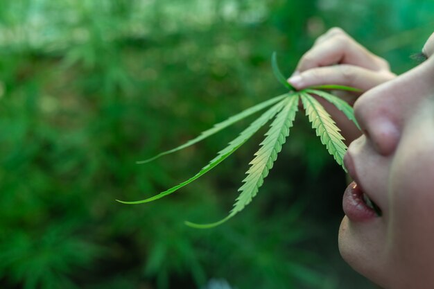 Ragazza felice che si leva in piedi e che tiene una cannabis.