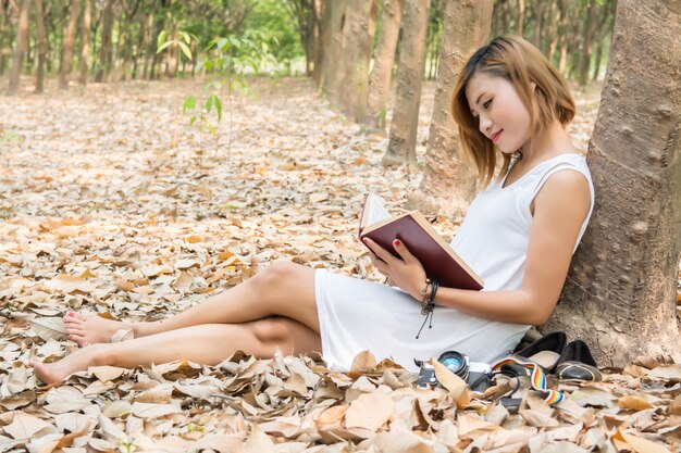 ragazza felice che si siede con un libro aperto